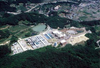 緑豊かな山間部に位置する大規模なすりかみ浄水場を上空から撮影した全景写真