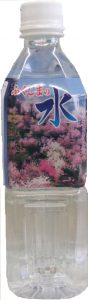 満開の桜やツツジなどのピンク色の花畑がデザインされ、その上部に大きな濃い青色の文字で「ふくしまの水」と書かれたラベルが貼られたペットボトルの写真