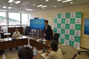 福島市のバックボードの前で市長が立って関係者の前で話をしている様子の写真