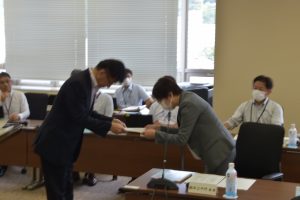 関係者が見守る中、市長からスーツ姿の委員に委嘱状を手渡ししている様子の写真