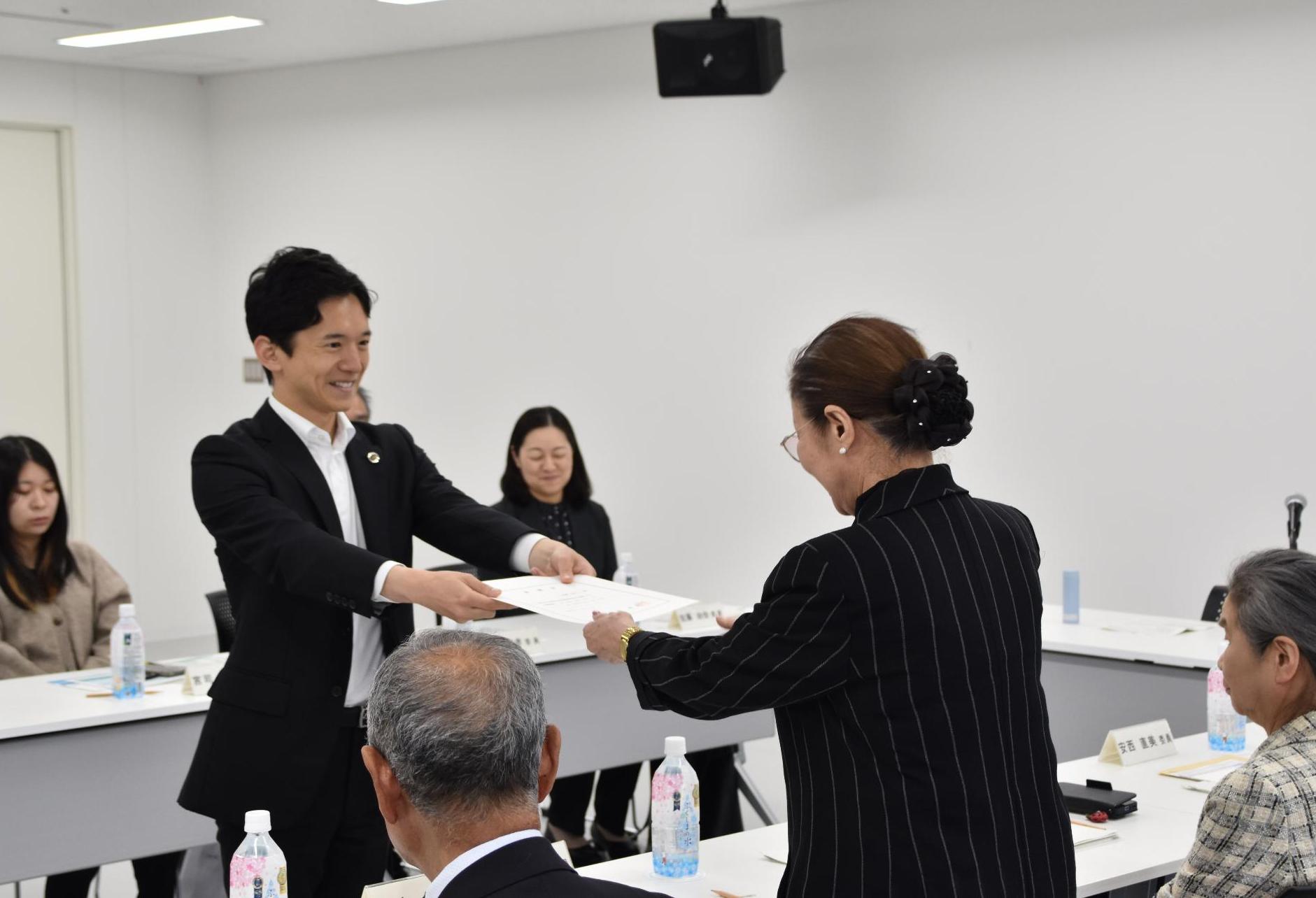 市長が水道事業経営審議会委員に委嘱状を交付する様子