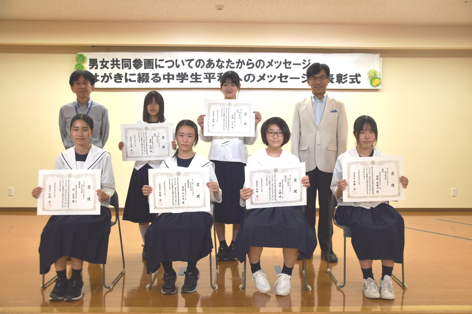 中学生が賞状を見せながら笑顔で記念撮影をしている写真