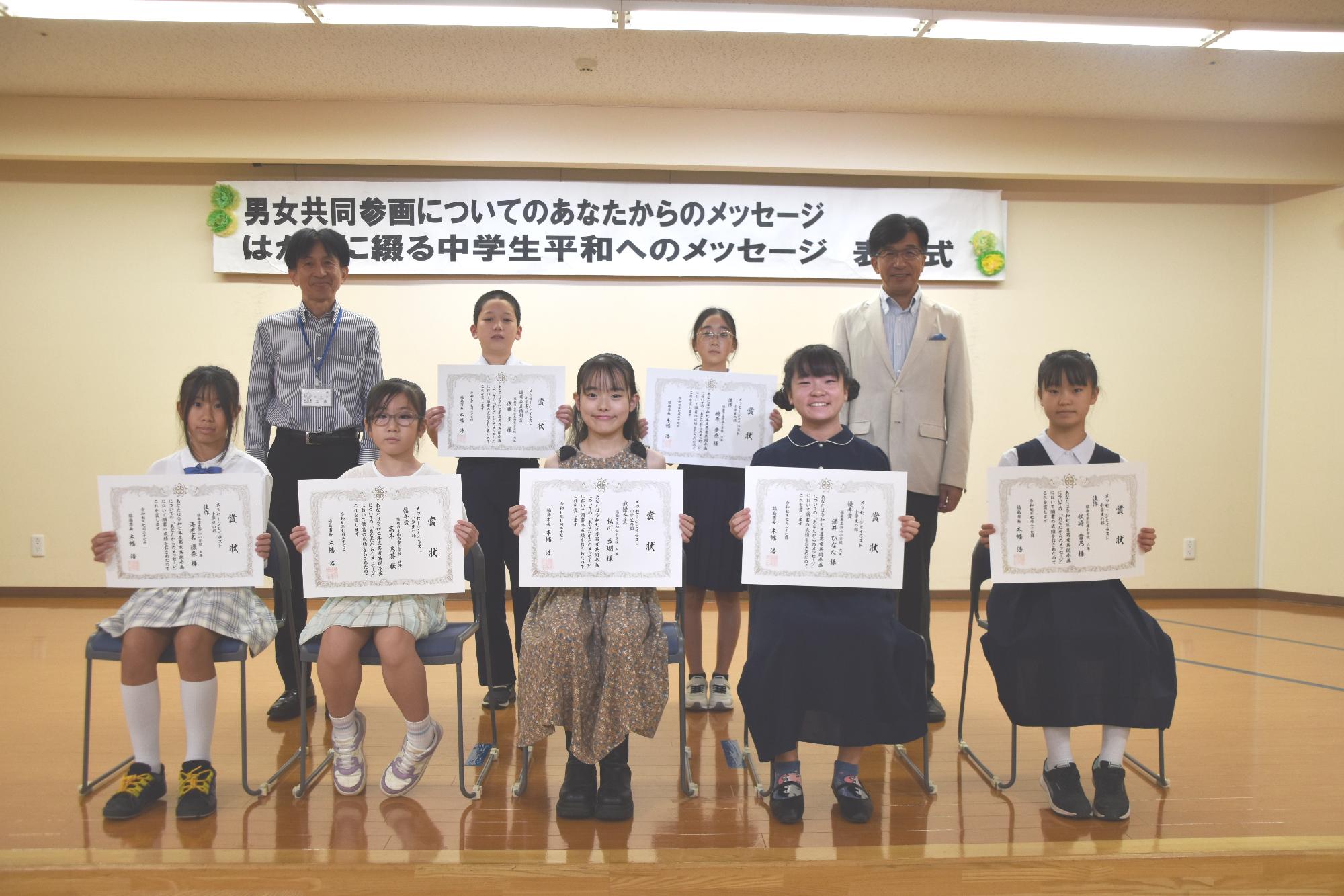 小学生の部の入賞者が賞状を見せながら笑顔で記念撮影をしている写真