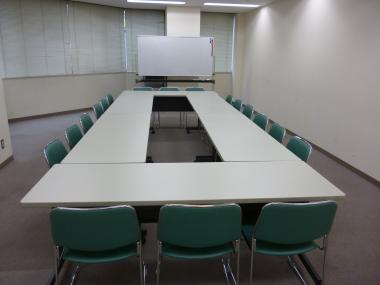ロ型に設置された長机に椅子がある小会議室の写真
