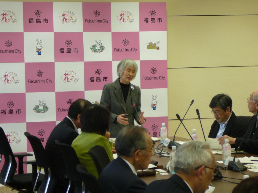 福島市のバックボードの前で会長が立って話をする様子と聞く参加者の写真