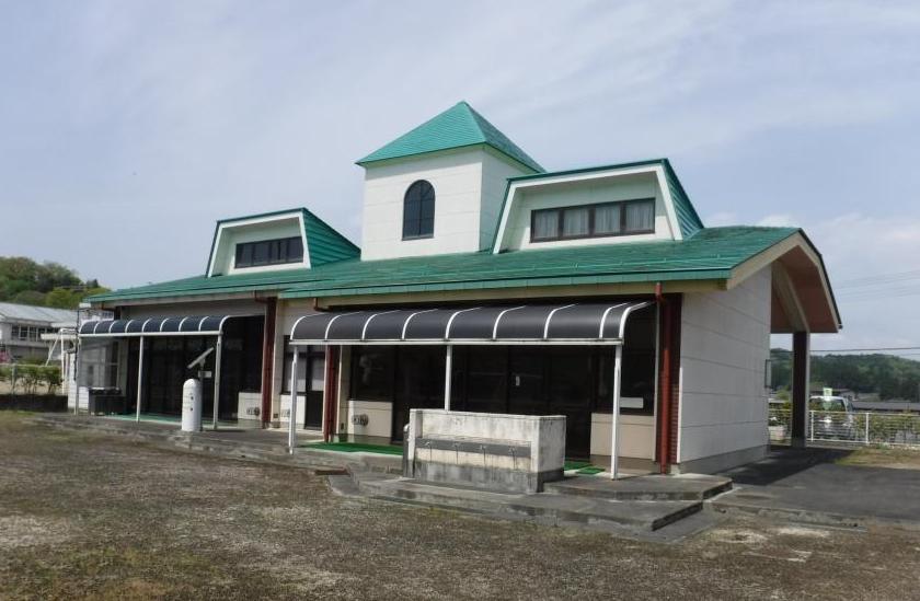 緑の屋根に白の外壁の平田幼稚園を園庭から写した写真