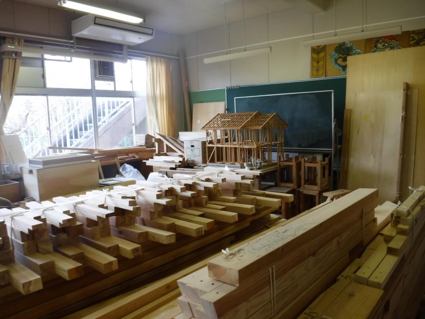 紐で結ばれた木材などの束が置かれた木造建築科教材置場の写真