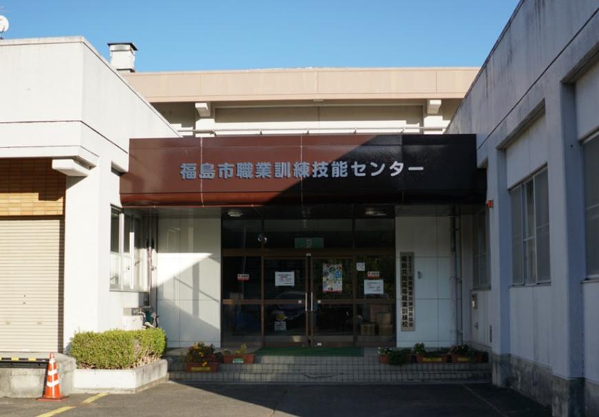 福島市職業訓練技能センターと書かれた白い外壁の正面玄関の写真