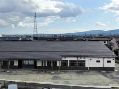 屋根が黒色で白壁の横長の新しくなった支所の建物外観の写真