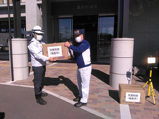 支援物資（福島市）と書かれた段ボール箱を男性2名が運んでいる写真