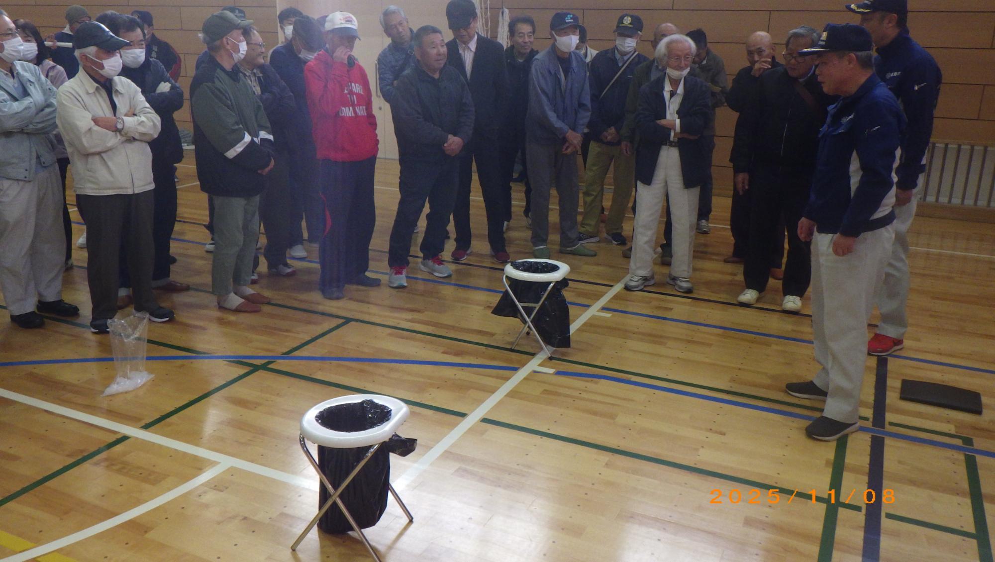 簡易トイレの使い方を説明をしている様子