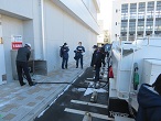 燃料を積んだトラックが建物に隣接した駐車場に停まっており、トラックの荷台の燃料タンクからホースを伸ばし、燃料を供給している様子の写真