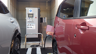 箱型の充電器の機械からケーブルをつなぎ、車に充電している様子の写真