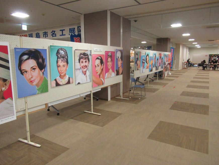 通路の片側にたくさんの人物画が展示されている写真