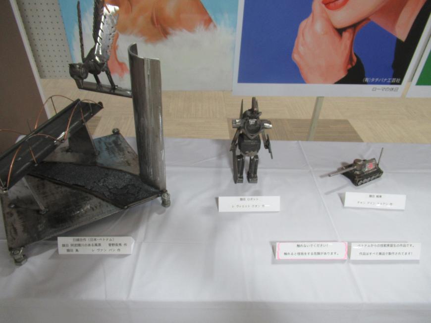 机の上に並べられ展示されている小さなロボットと戦車の写真