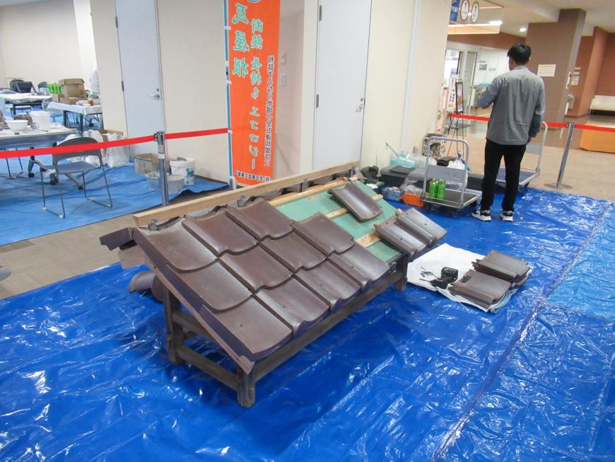 ブルーシートの上に新品の瓦が並べられている写真