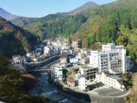山に囲まれた川沿いに宿が建ち並ぶ土湯温泉街を高台から撮影した写真