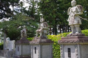 間隔をあけて設置された土台の上に佐藤一族の3つの像が並んでいる写真