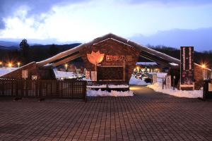 端に雪が避けられた中央に大きく「四季の里」と書かれた三角屋根の建物外観の写真