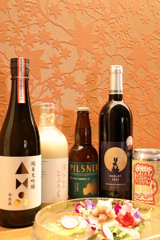 透明のお皿に盛り付けられたサラダと、5本のお酒が並んだペアリングメニューの写真