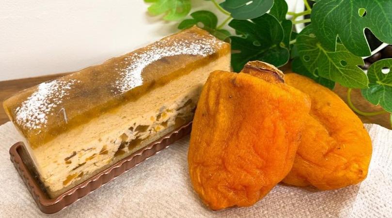 オレンジ色の2つのあんぽ柿と、長方形で果肉が練りこまれたあんぽバターケーキの写真