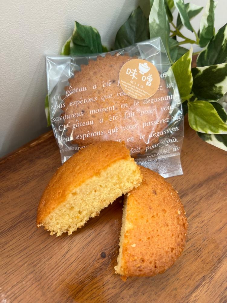 透明の袋に入った商品とマドレーヌを半分にカットした、みそドレーヌの写真