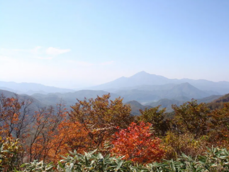 周囲に靄がかかり遠くの磐梯山が霞んで見える湖見峠の写真