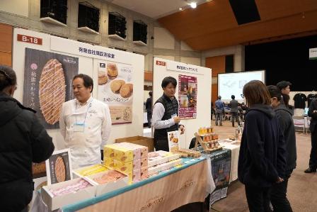 食品販売の男性スタッフから説明を受けている女性の写真