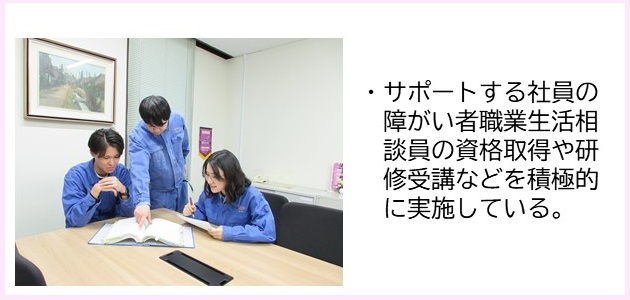 ・サポートする社員の障がい者職業生活相談員の資格取得や研修受講などを積極的に実施している。（お揃いの青色の作業着を着た3名のスタッフがテーブルの上に置かれた資料を見ている写真）