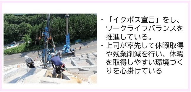 ・「イクボス宣言」をし、ワークライフバランスを推進している。・上司が率先して休暇取得や残業削減を行い、休暇を取得しやすい環境づくりを心掛けている（青色の大きな機械を使って法面補修工事を行っている写真）