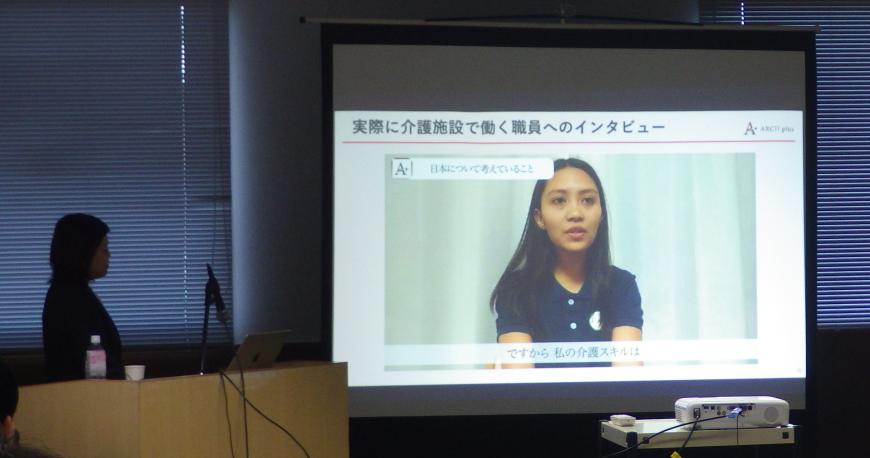 日本で働くフィリピン人の女性のインタビューがスクリーンに映し出されている写真