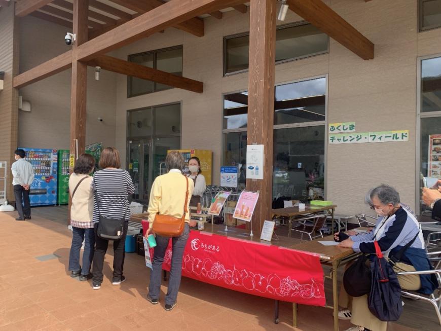 道の駅ふくしまの店先に赤い暖簾がかかった長机が設置され3名のお客さんが並んでいる写真