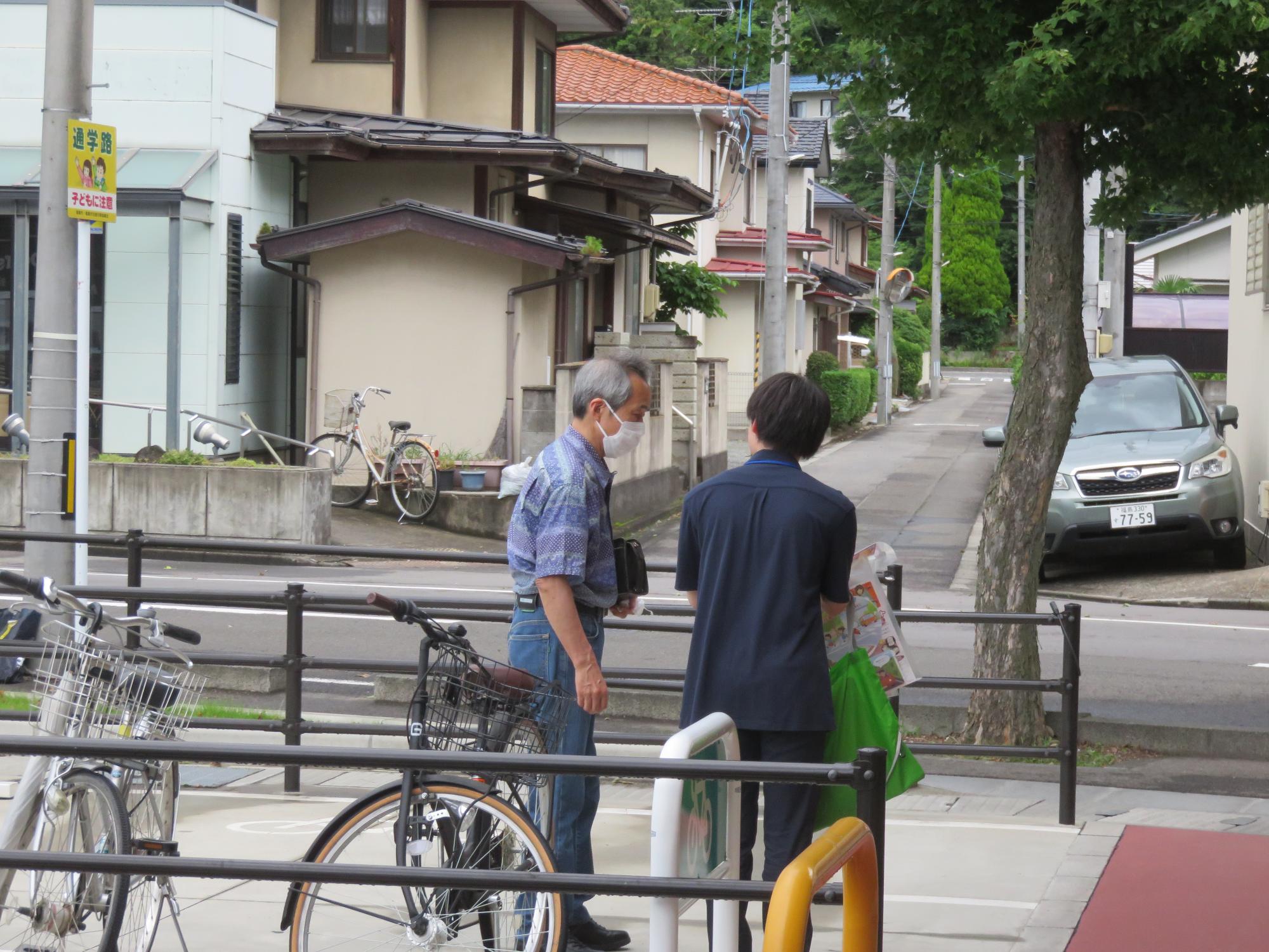 お店の利用者へシートベルト着用を呼びかけるチラシを配布する写真