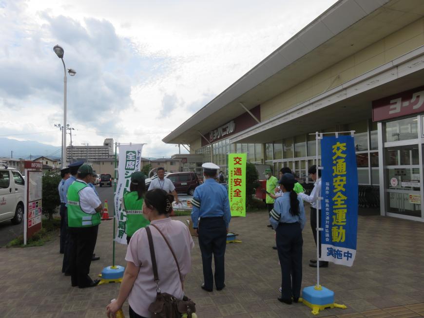 交通安全ののぼりが立ったヨークベニマル野田町店の入り口前に集まったキャンペーン参加者たちの写真