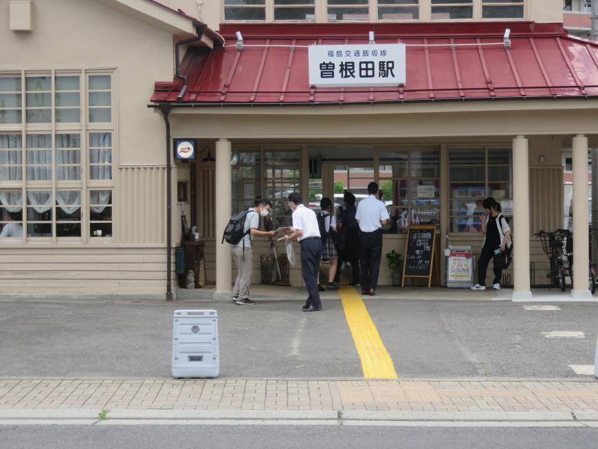 曽根田駅の前でチラシを配布する男性の写真