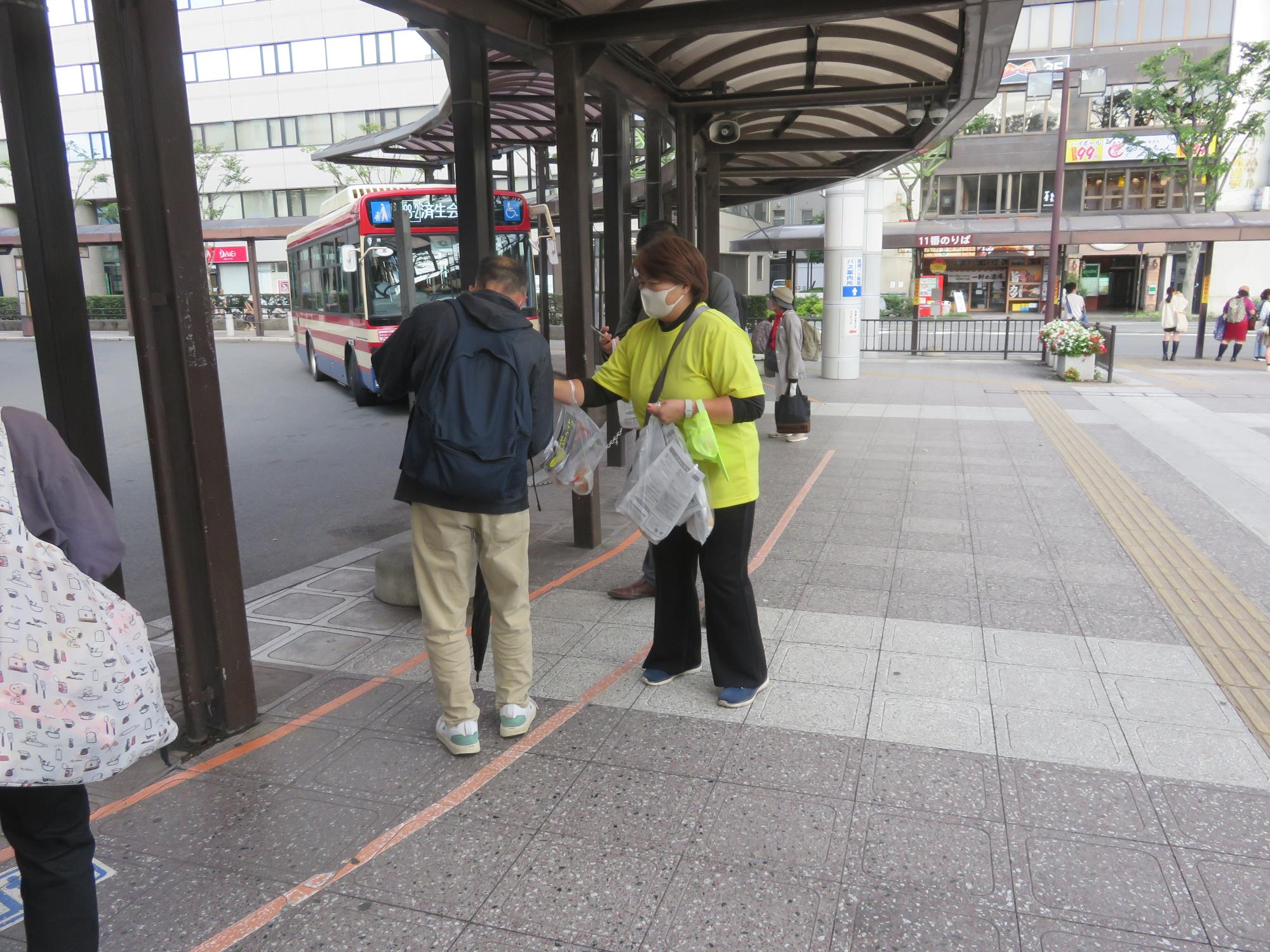 駅前広場利用者へ梨を配布する様子