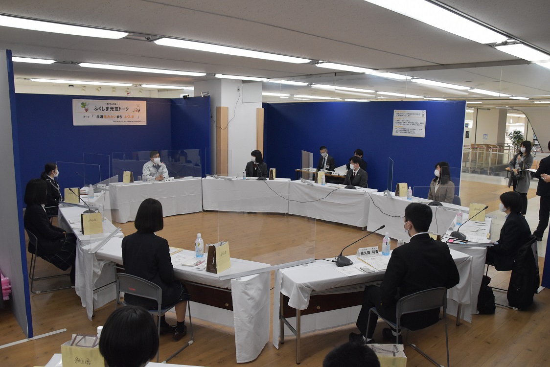 多目的交流スペース会場に設置された椅子と机に座り、意見交換会が行われている様子の写真