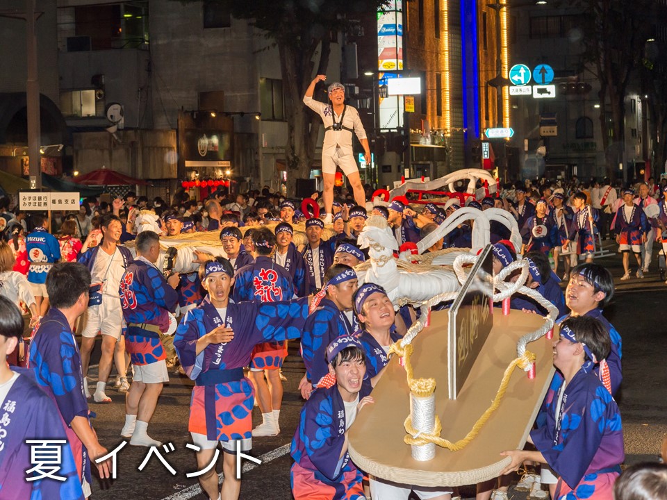 草鞋の神輿を大勢の法被姿の参加者が持って運んでいる写真