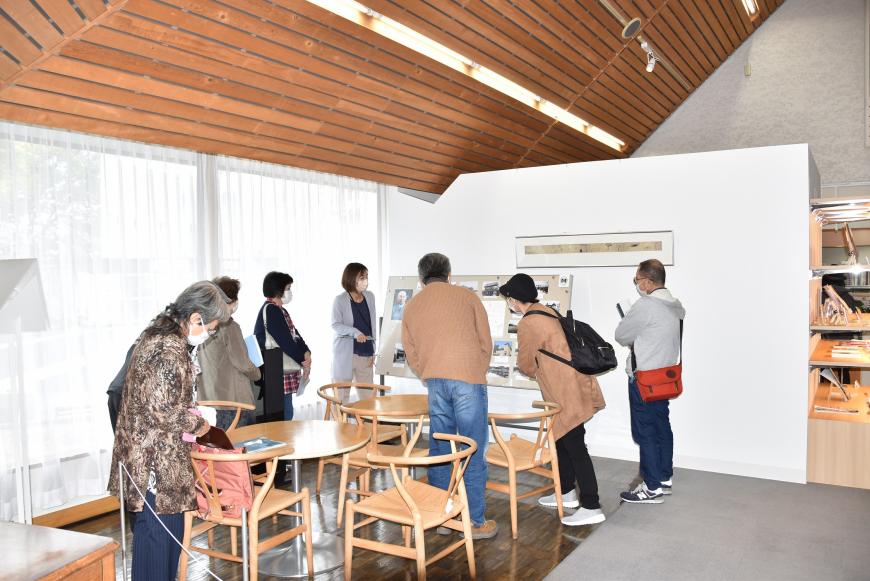 古関裕而記念館内に展示されている資料を係の方が説明している様子を参加者が聞いている写真