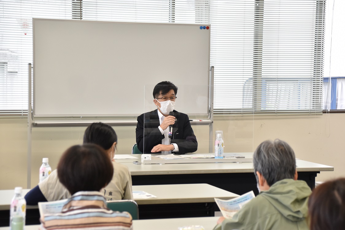 ホワイトボードの前に座った市長が参加者に向かって話をしている様子の写真