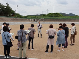 資料を手に持ちながら前方にいる男性の話を聞いている参加者の後方から写した写真