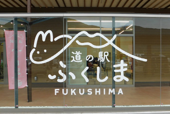 透明のガラスに白文字でウサギと山が合体したイラストと「 道の駅ふくしま」と書かれた写真