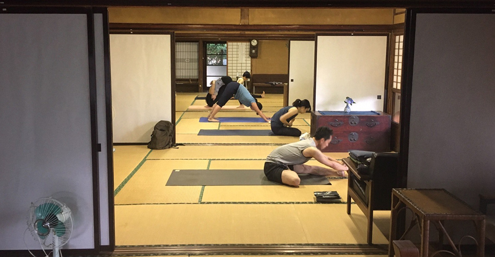 二間続きの和室に5人の方がヨガマットを敷きヨガをする様子の写真