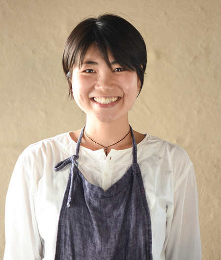 グレーのエプロンを付けた近藤 仁美さんの写真