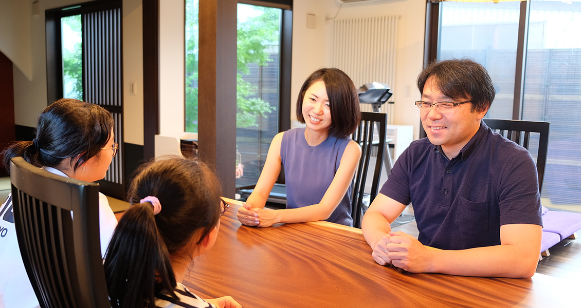 テーブルを2人の子どもと中島さん夫婦が向かい合って座り話をしている写真