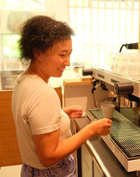 パクさんがコーヒーマシーンの前に立っている横顔の写真