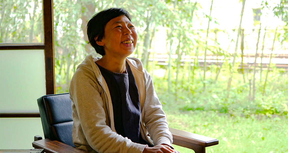 窓をあけた縁側の椅子に腰かけた笑顔の佐藤 宏美さんの写真