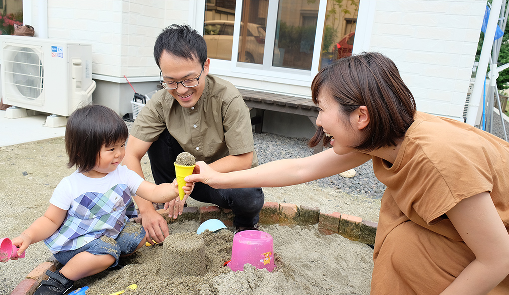 篠田さん家族が庭で砂遊びをする様子の写真