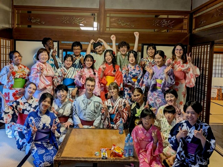 古民家内の和室に設置されたテーブルの周りに浴衣を着た方々が並んでいる写真