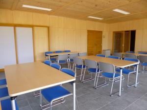 左右に3脚ずつ椅子が設置されている長方形をしたテーブルが3台置かれている休憩室内の写真